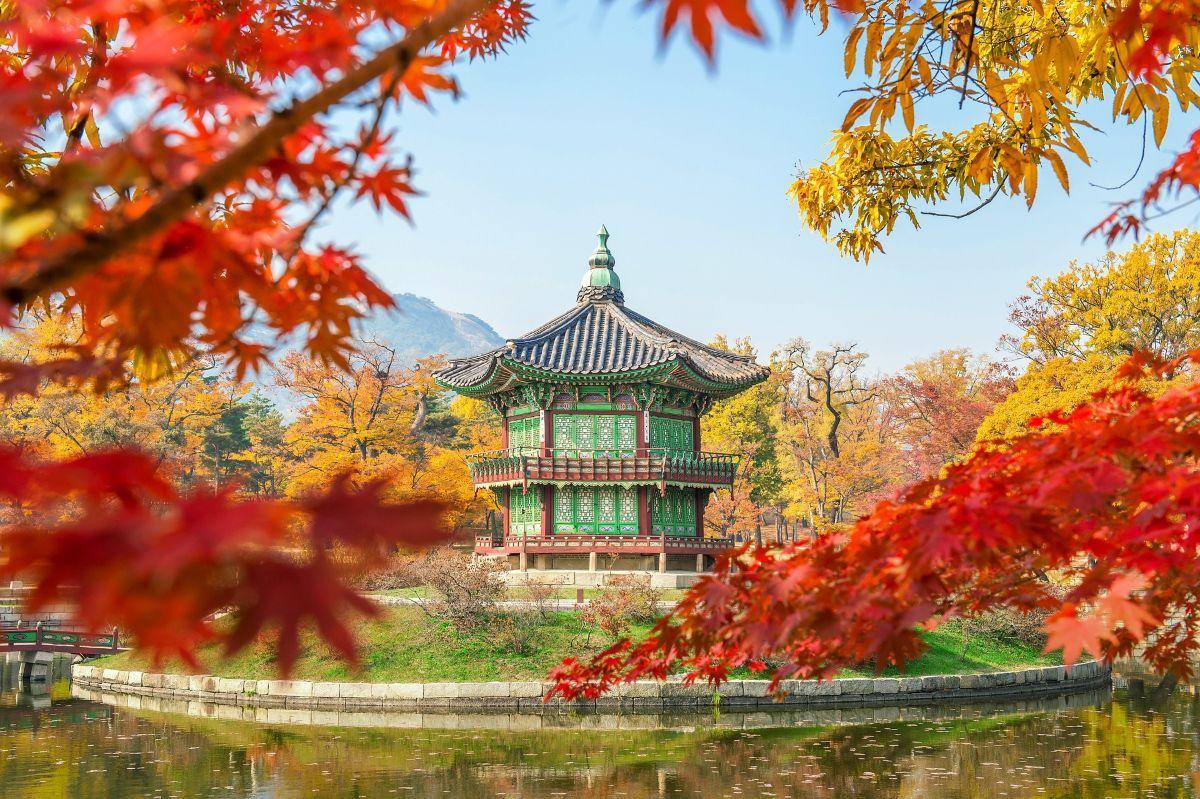 Hyangwonjeong pavilon a Gyeongbokgung palot&aacute;ban őszi lombok k&ouml;z&ouml;tt D&eacute;l-Kore&aacute;ban