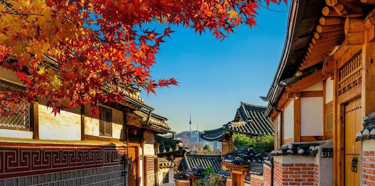 Bukchon Hanok falu hagyom&aacute;nyos h&aacute;ztetői Sz&ouml;ulban a Namsan-toronnyal