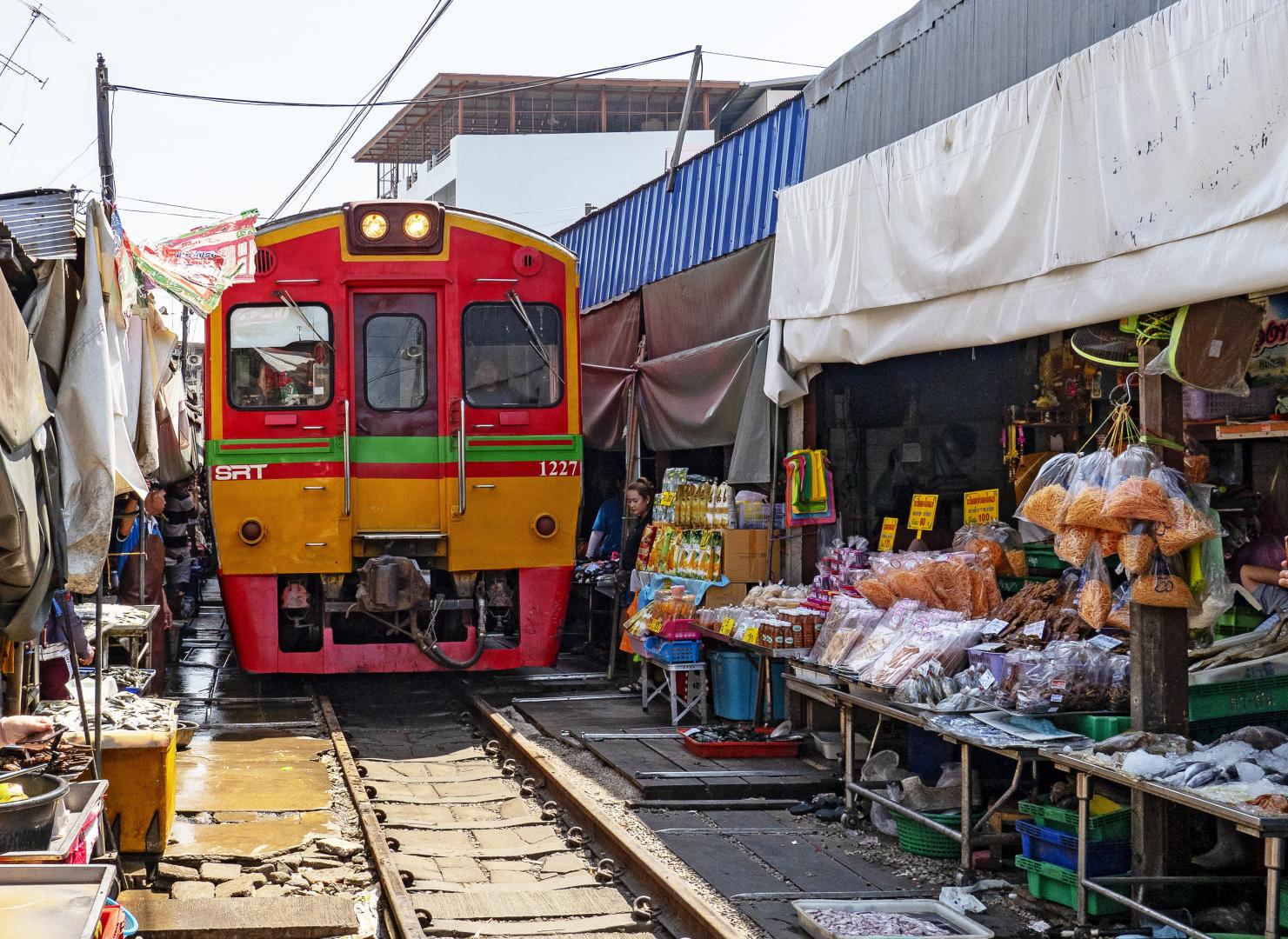 Vonat halad kereszt&uuml;l a Maeklong vas&uacute;ti piacon Thaif&ouml;ld&ouml;n